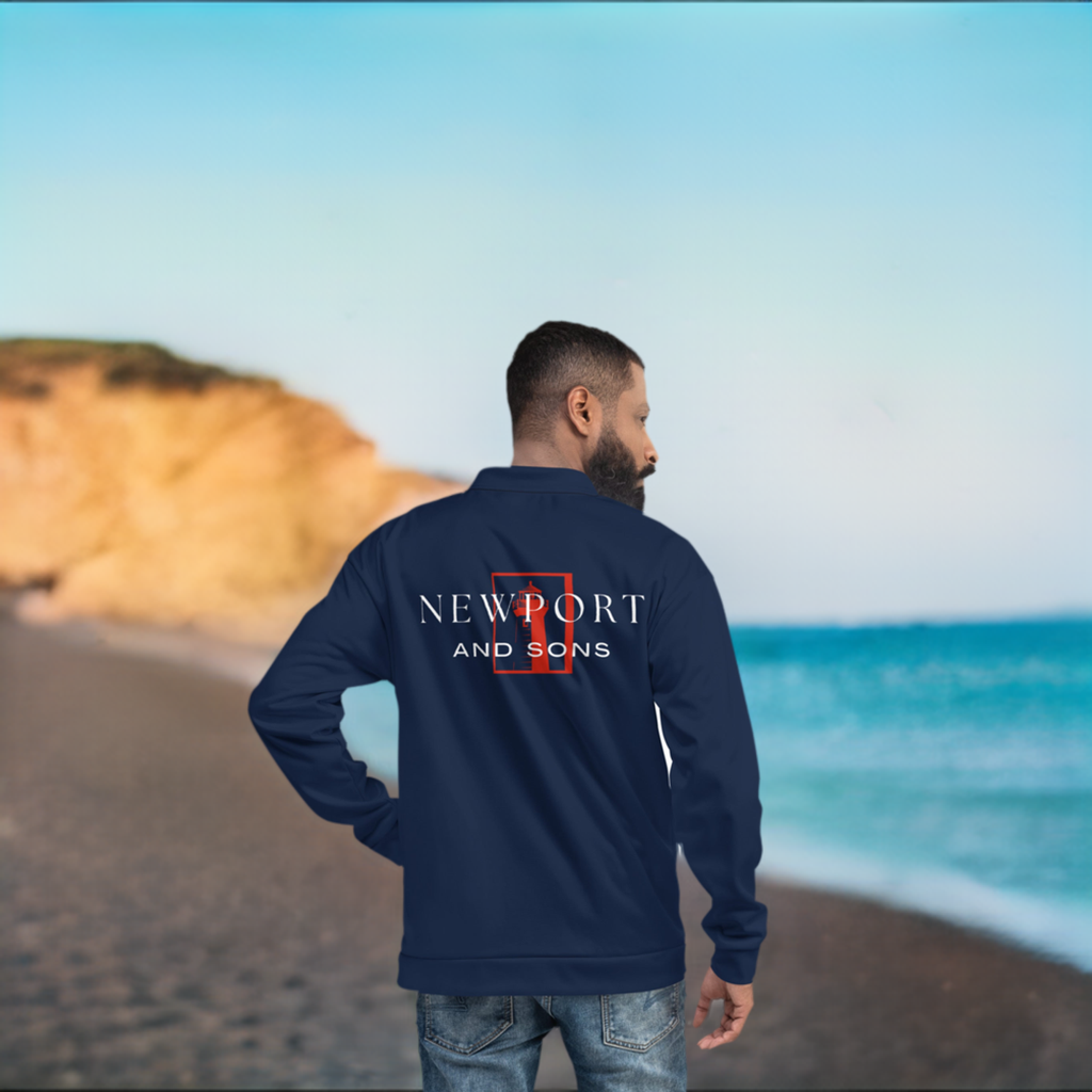 A man standing at the beach wearing a Newport and Sons jacket.